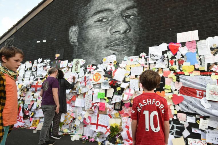 I manifestanti si riuniscono al murale vandalizzato di Marcus Rashford sul razzismo nel calcio inglese